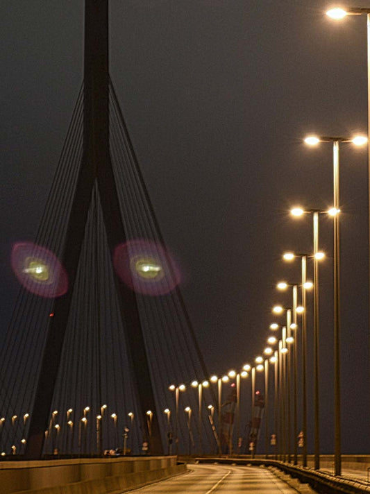 Foto der Köhlbrandbrücke in Hamburg bei Nacht, Lampen beleuchten die Straße, Detailansicht der Lampen