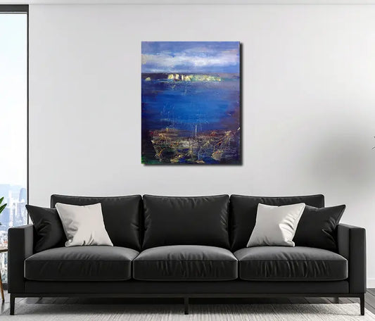 Eine Küstenlandschaft mit heller Steilküste am Horizont, Himmel mit Wolken, an heller Wand hängend mit dunklem Sofa