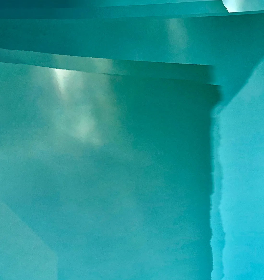 Abstraktes Foto das blaue und türkise Strukturen zeigt die durch Stoff fotografiert wurden, Detailansicht die an grünliche Gletscherstrukturen erinnern. 