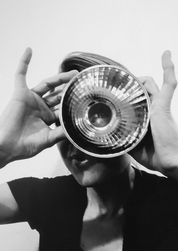Portrait Franka Schimankowitz, schwarz weiß, schaut  durch den Reflektor einer Lampe