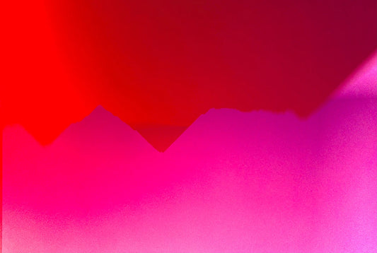 Das abstrakte Foto zeigt abstrakte Strukturen in pink und rot die an Berge erinnern.
