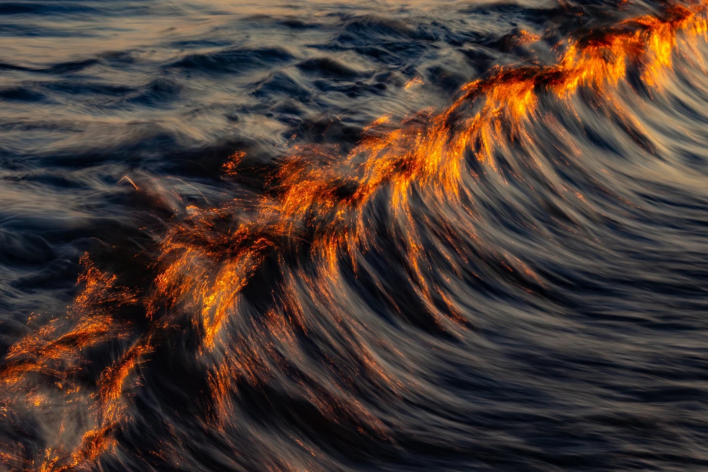 Preisgekrönte Fotokunst Burning von Malte Lüdemann – Glühende feuerrote Wellenkrone im dunklen Wasser als Langzeitbelichtung, 90 x 60 cm und 120 x 80 cm, Kunst-Direkt.de / Newart.gallery