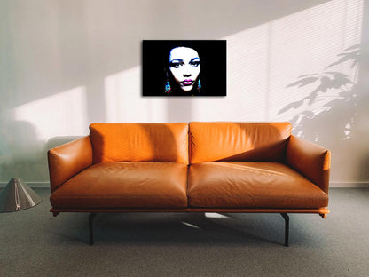 Das Portrait einer farbigen Frau mit farbigen Ohrringen, dunkler Hintergrund, an Wand hängend mit braunem Sofa