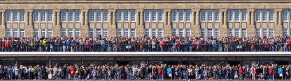 eine große Menschenmenge steht an einem Geländer und wartet auf etwas., Panoramabild