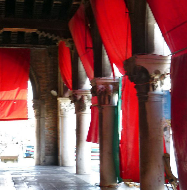 Ein Torgang in Venedig, Säulen und rote Tücher im Sonnenschein, Details der roten Tücher