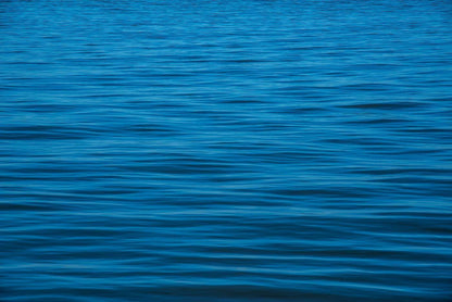 Die Meeresoberfläche mit Wellen, kein Himmel, nur blaues Wasser mit Wellen