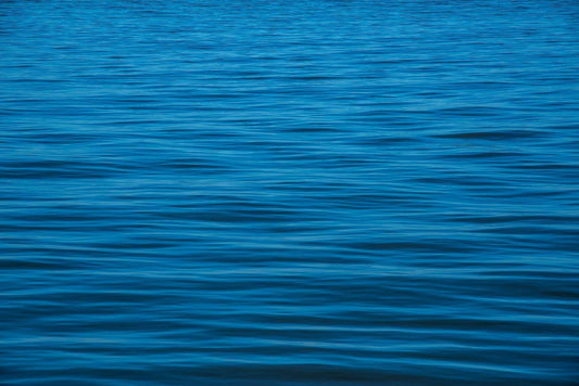 Die Meeresoberfläche mit Wellen, kein Himmel, nur blaues Wasser mit Wellen