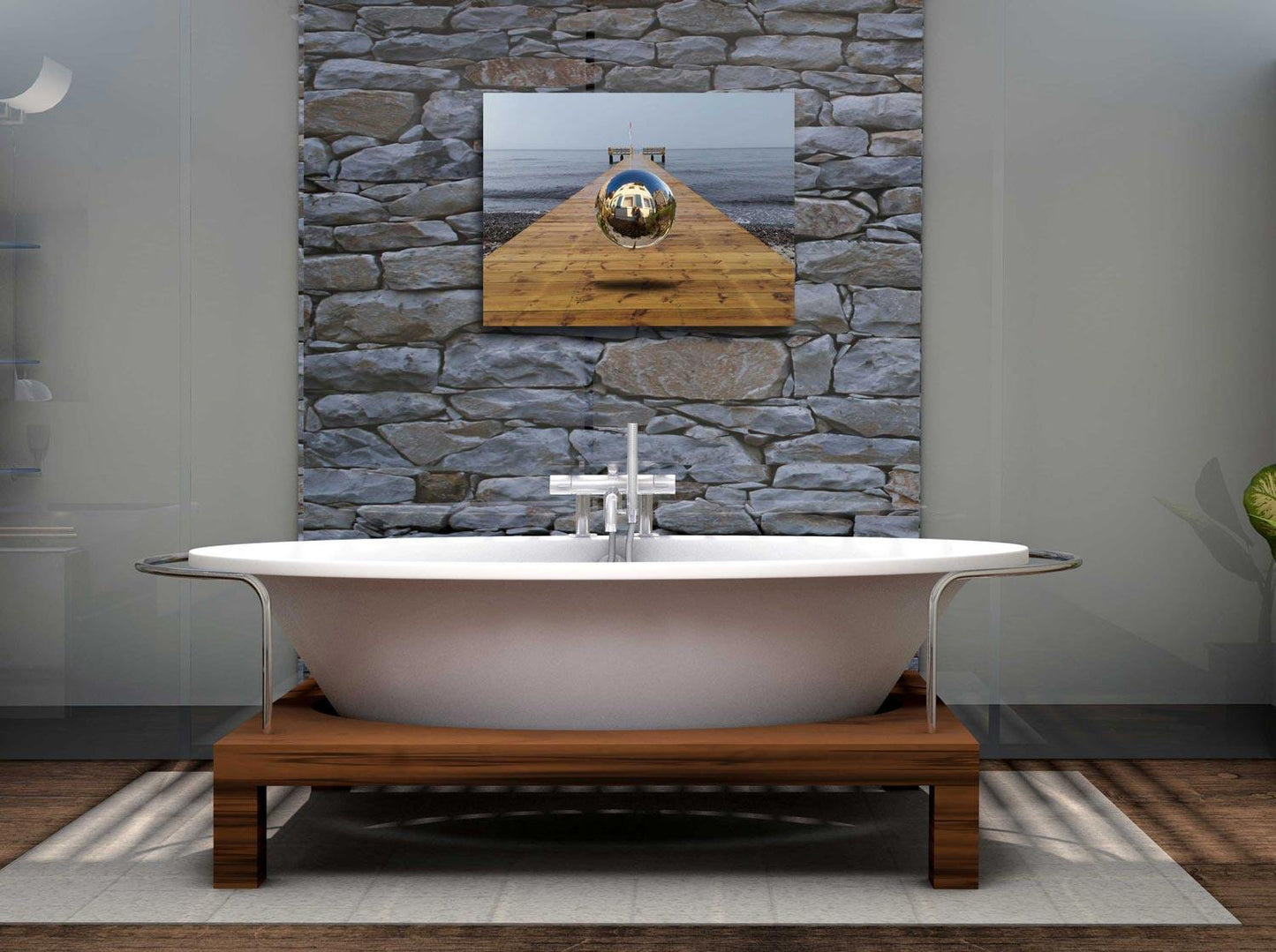 Eine Kugel schwebt über einem Steg der in die Ostsee führt-Surreales Werk, an einer Steinwand über eine  Badewanne hängend.